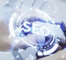 A close-up, abstract image of a hand near a translucent, glowing digital circle with the letters "SEO" in the center, symbolizing technology and digital optimization.